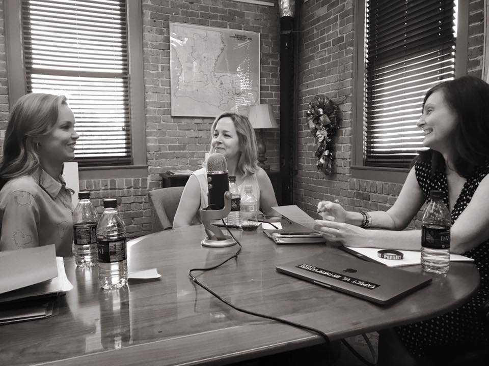 Women in Politics Podcast photograph of three white women at a conference table with a microphone.